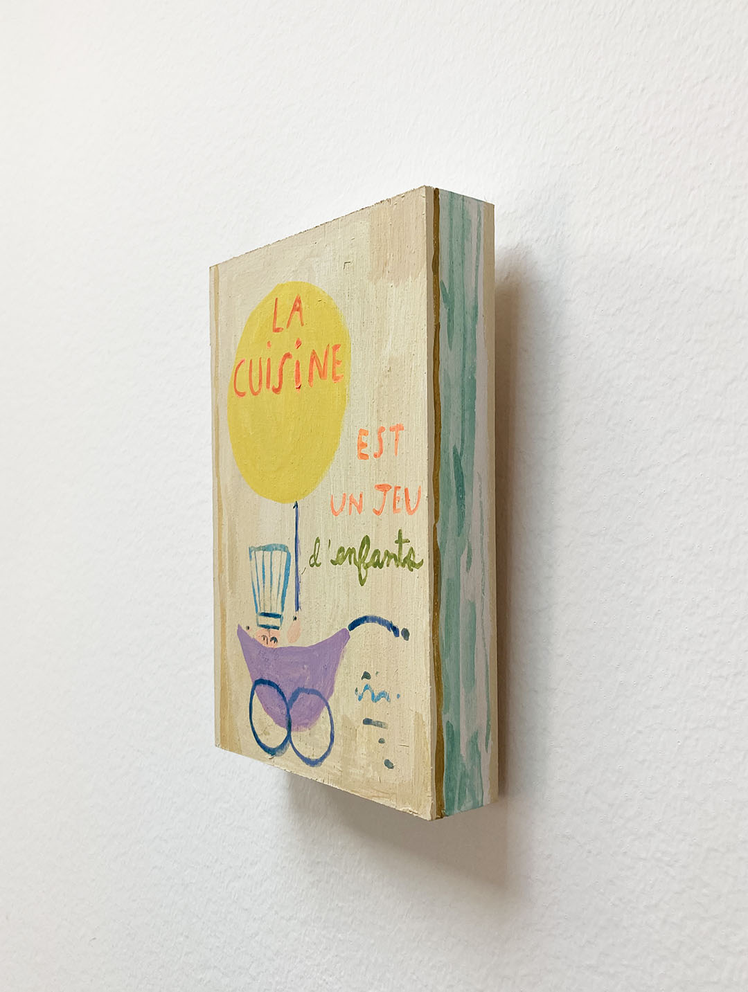 La Cuisine est un jeu d'enfants Cookbook, painting on wood block.