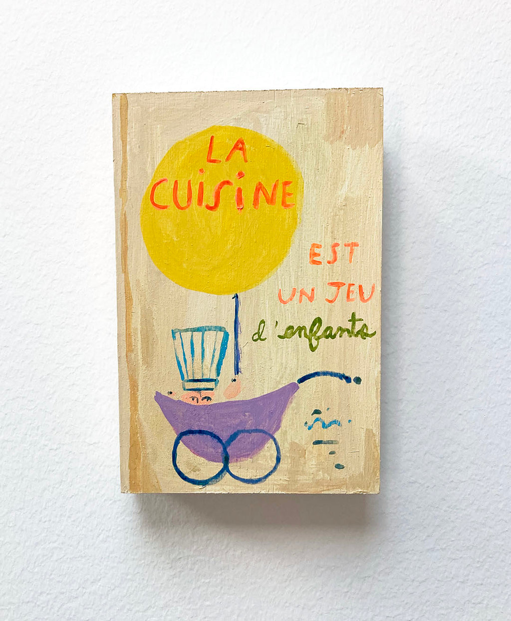 La Cuisine est un jeu d'enfants Cookbook, painting on wood block.